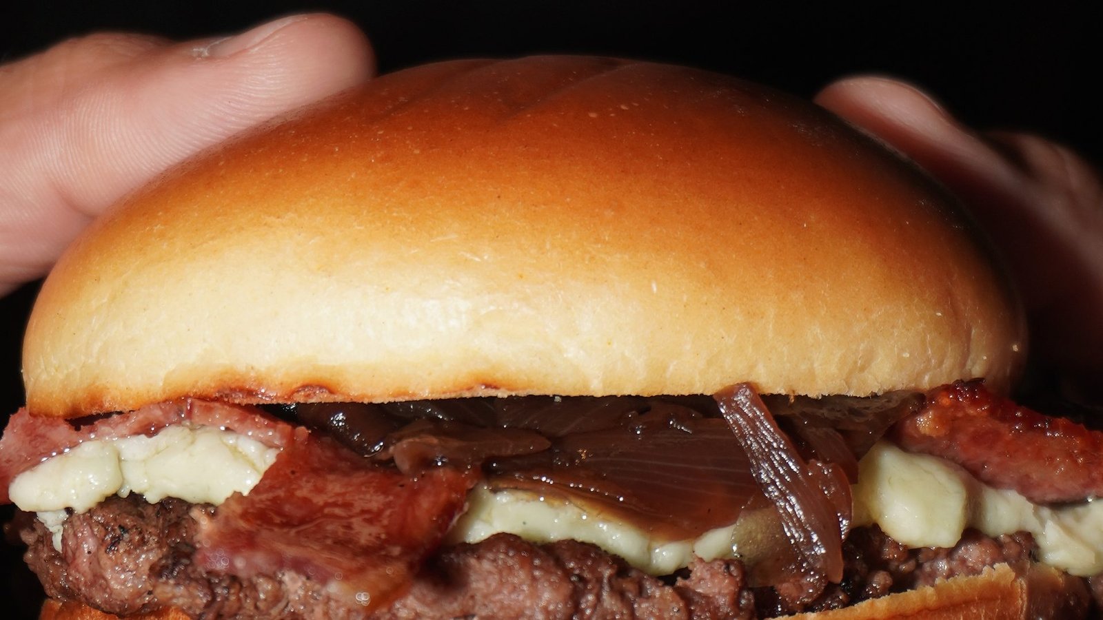 Smash burger servido nas mãos no Cine Café